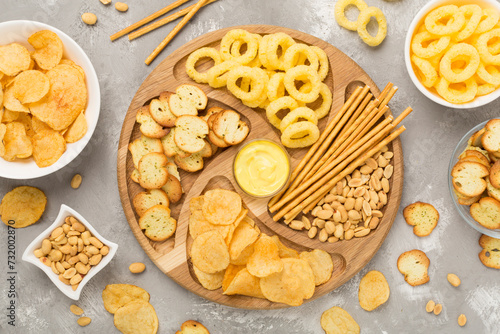 Various unhealthy snacks on concrete background, top view