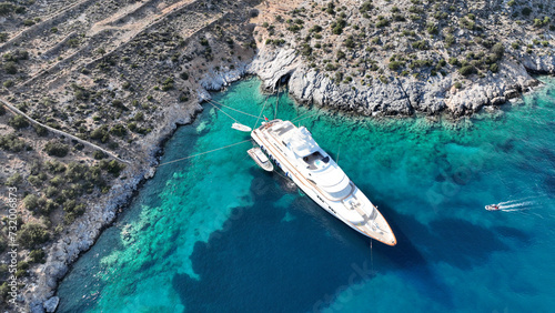 Aerial drone photo from tropical exotic paradise secluded rocky island bay with deep turquoise and sapphire sea forming a blue lagoon visited by yachts and sail boats in Caribbean exotic destination