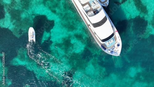 Aerial drone top down photo with copy space of luxury yacht anchored in tropical exotic island with crystal clear turquoise sea