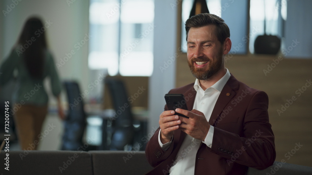 Smiling professional using mobile phone in modern office closeup. Happy worker Smiling professional using mobile phone in modern office closeup. Happy worker