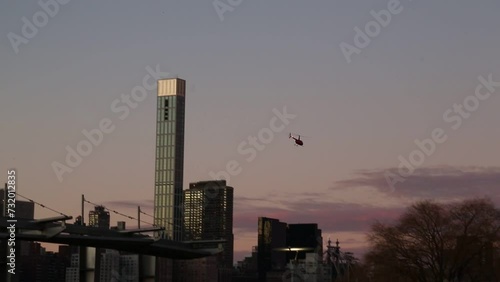 helicopter flying over the east river between manhattan and queens (gantry park, long island city) tall buildings and skyline at sunset (chopper, flight)