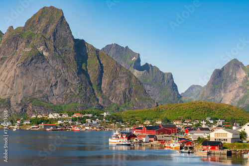 The most famous fishing village Reine with traditional red fisherman's cabins on Lofoten islands, Nordland, Norway. Amazing nature with dramatic mountains and peaks, open sea, pier and bay photo