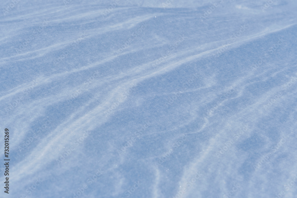 Snow after wind forms white canvas swirling patterns. Light, sparkling, with ice crystals. Unique natural texture and tranquility winter landscape. Snow after wind forms white canvas swirling patterns. Light, sparkling, with ice crystals. Unique natural texture and tranquility winter landscape.