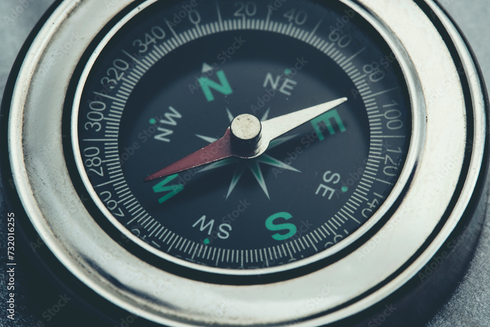 Metallic compass indicating westward direction. Metallic compass indicating westward direction.