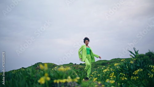 Girl dancing sensual movements in field flowers. African woman performing dance 