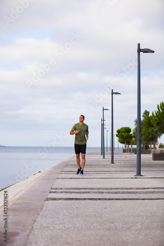 Young man running near the Tejo river