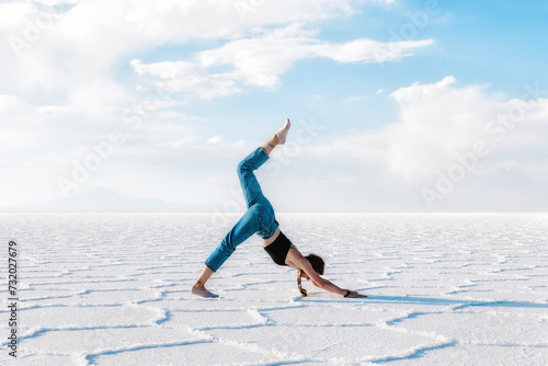 A girl does yoga outdoors. Salar de Uyuni salt plateau. Bolivia