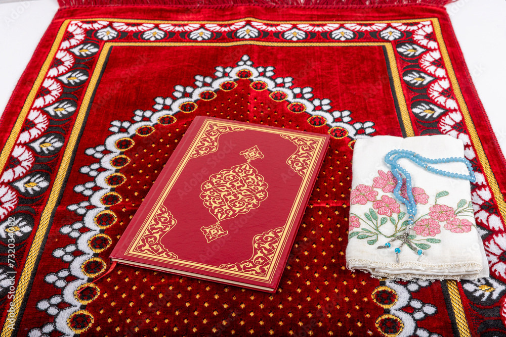 A magnificent place where the Quran and prayer beads are exhibited on prayer rugs. Set of Islamic religious prayer accessories, Quran rosary on prayer rug, top view. A magnificent place where the Quran and prayer beads are exhibited on prayer rugs. Set of Islamic religious prayer accessories, Quran rosary on prayer rug, top view.