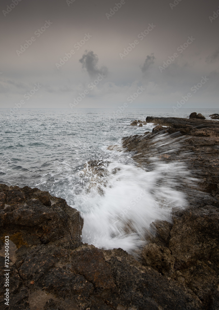Windy waves splashing with power on a rocky coast in winter. Stormy weather outdoor Windy waves splashing with power on a rocky coast in winter. Stormy weather outdoor