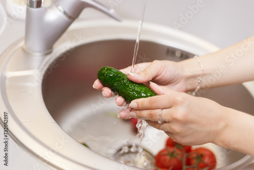 Person washing cucumber