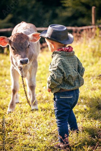 Little Toddler Cowboy Kid with Little Cute Calf the Cow