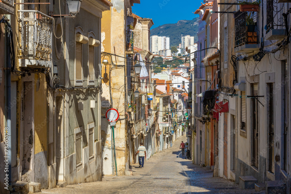 Setubal, Portugal. 10 August 2023. A typical old European street, narrow with its ancient buildings, European city. A cityscape of Setúbal with tiny shops and cafes.