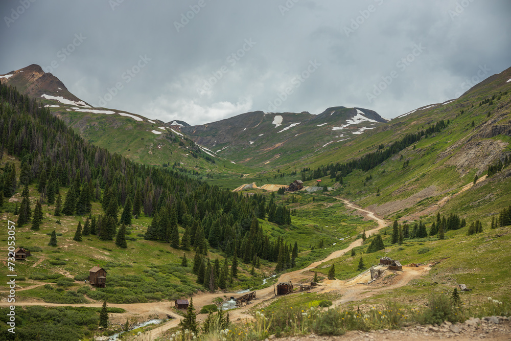 Old mining town in mountain tundra valley with summer storm skies