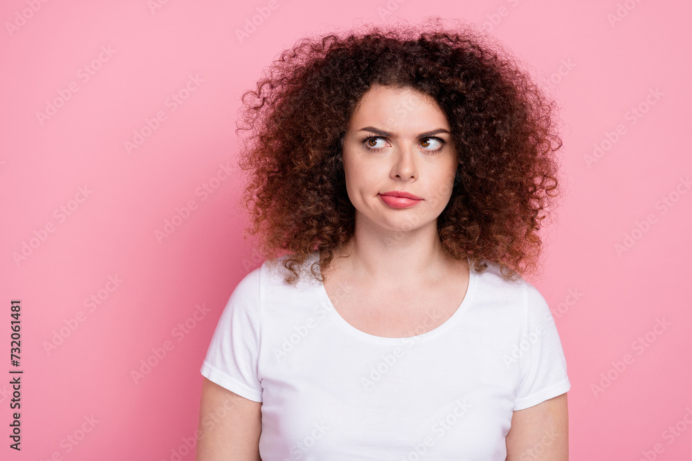 Photo of pensive woman with perming coiffure dressed white t-shirt look at proposition empty space isolated on pink color background