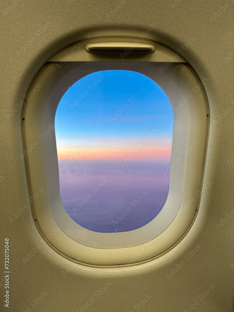 Naklejka premium Sunset through an airplane window