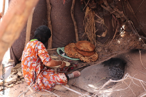 Quadro su tela Moroccan local nomadic bedouin family live in nomad tent camp in native berber tradition in african Sahara desert and prepare traditional turkish flatbread in hot oven near Merzouga, Morocco, Africa