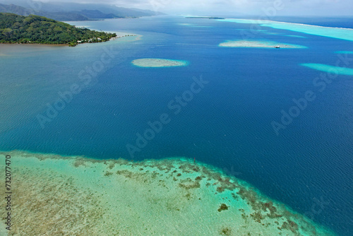Aerial view of turquoise water and the coral reef in the South Pacific Ocean near the island of Raiatea on the south eastern coast of Raiatea