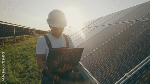 Male engineer collects effective information about solar panels on laptop.