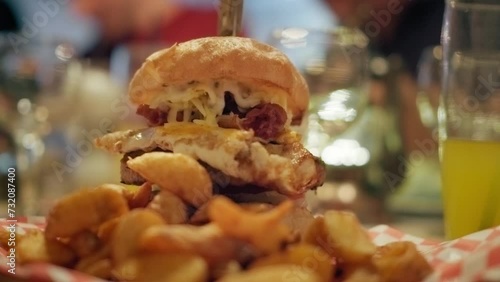 4K shot of a tasty homemade hamburger in a small american restaurant, unhealthy fast food, egg barbecue burger meal, cinematic slow motion video