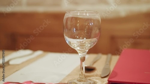 Empty wine glass on a table in a fancy restaurant, cinematic 4K video