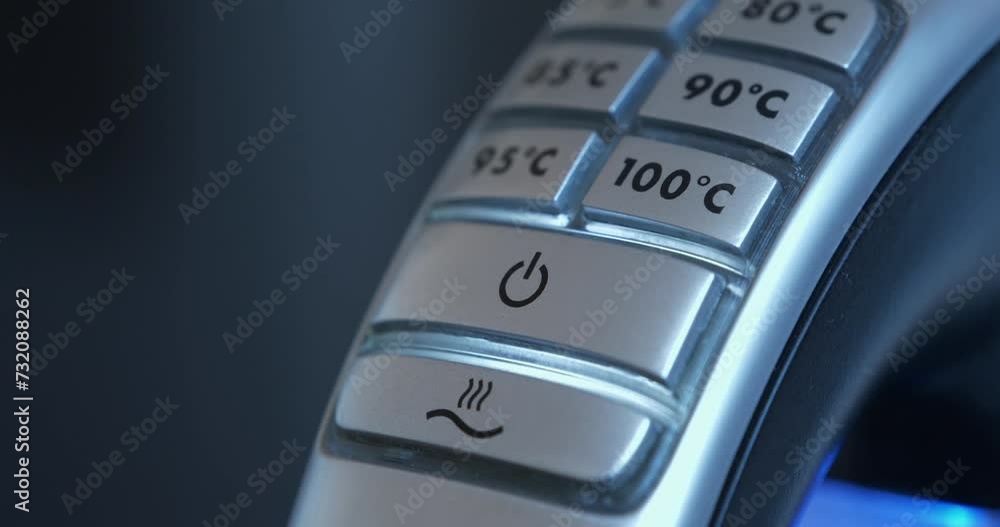 Man turns on the kettle. Finger presses button on kettle. Turning on an electric kettle with adjustable water heating temperature Man turns on the kettle. Finger presses button on kettle. Turning on an electric kettle with adjustable water heating temperature