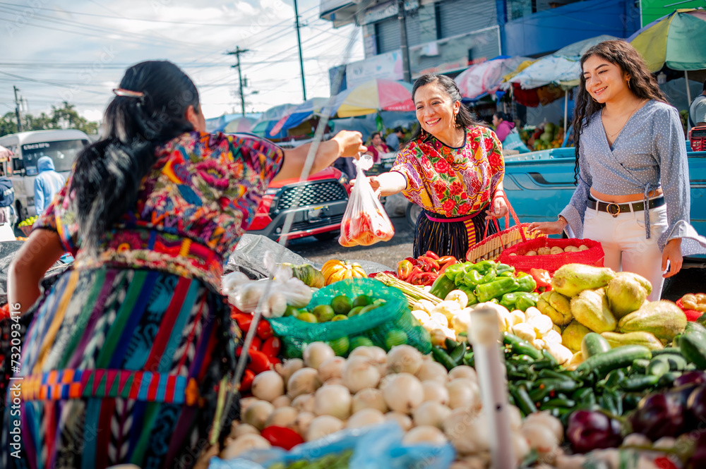 Women in local market buying fresh vegetables.