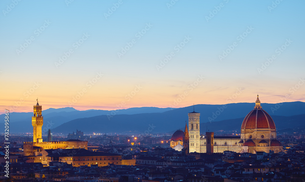 Florence, Tuscany, Italy. Panorama Sunset view at Duomo Santa Maria del Fiore cathedral and Palazzo Vecchio Tower. Panoramic of Firenze during sunset. Scenic landscape mountains evening sky.