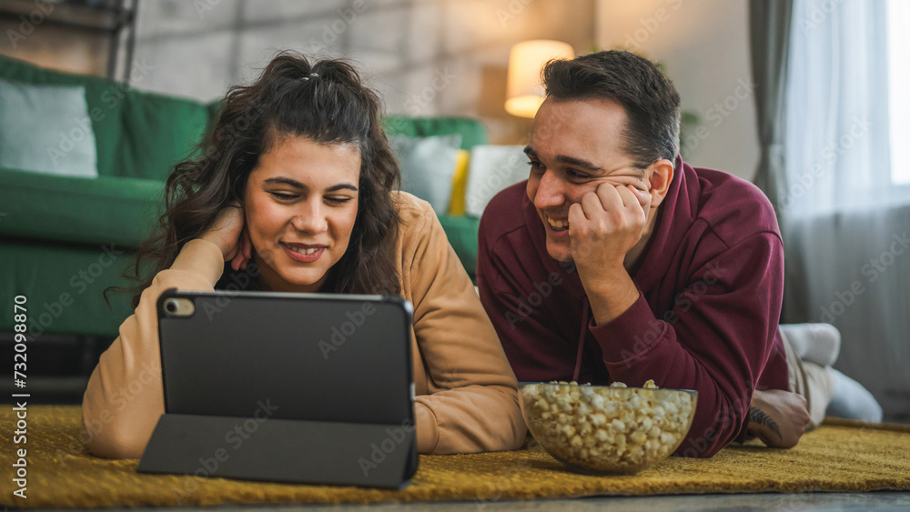 Couple man and woman at home watch movie video on digital tablet Couple man and woman at home watch movie video on digital tablet