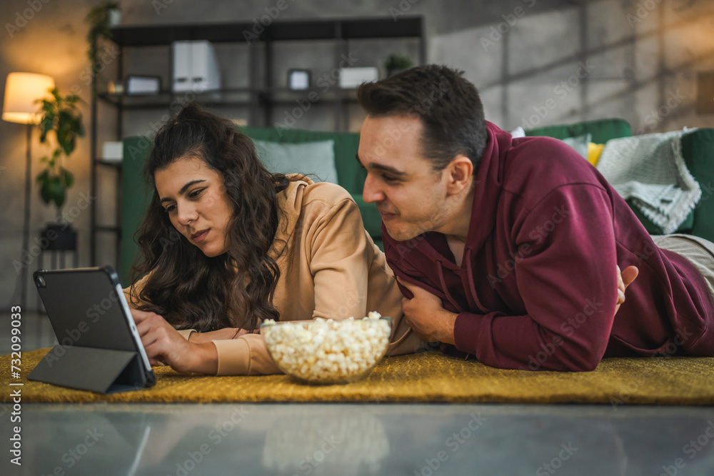 Couple man and woman at home watch movie video on digital tablet Couple man and woman at home watch movie video on digital tablet