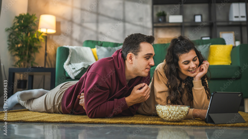 Couple man and woman at home watch movie video on digital tablet Couple man and woman at home watch movie video on digital tablet
