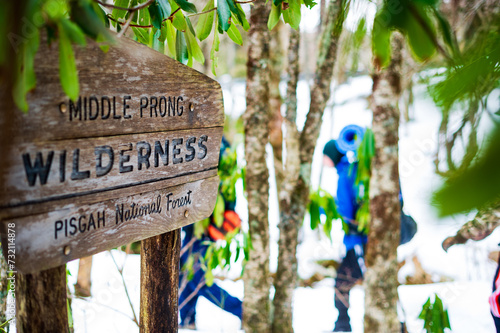 Backpackers pass a National Forest wilderness sign in winter. photo