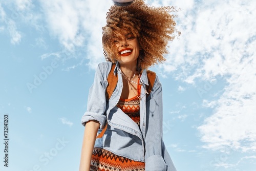 Smiling Woman in Beach Lifestyle, Dancing with Open Mouth in Happy Hippie Style, Enjoying Freedom and Nature: Portrait of a Young Model in Curly Hair, Under Wide Angle Lens, during Fun-filled Summer