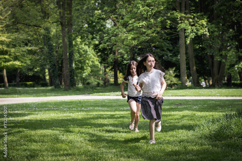 Two girls running in the park on a summer day. Two girls running in the park on a summer day.