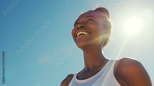 Fitness, black woman and happy athlete smile after running, exercise and marathon training workout. Blue sky, summer sports and run of a African runner breathing with happiness from sport outdoor photo
