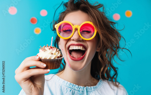 Happy woman wearing novelty glasses holding cupcake Birthday Celebration