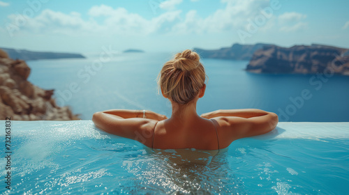 woman relaxing in the pool looking out over the ocean , Young woman on vacation at Santorini, women at the swimming pool looking out over the Caldera ocean of Santorini, Girl at the infinity pool Oia  © Fokke Baarssen