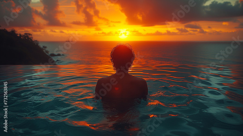silhouette of a person in the sunset at the pool   a Luxury swimming pool in a tropical resort  and relaxing holidays in Seychelles islands. La Digue  Young man during sunset by swim pool 