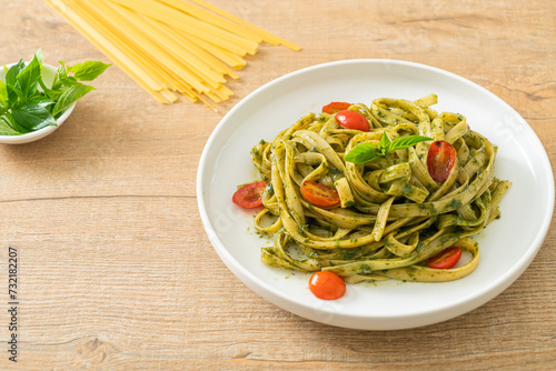 fettuccine spaghetti pasta with pesto sauce and tomatoes