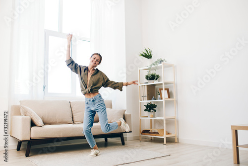 Jumping for Joy in a Playful Home: Happy Woman Dancing on Sofa in a Relaxing Living Room © SHOTPRIME STUDIO