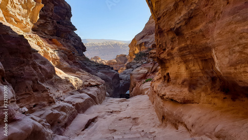 Scenic landscape view of hidden walkway through red rocky mountainous desert terrain in the ancient city of Petra  Jordan