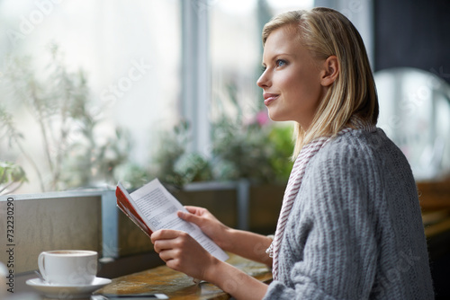 Coffee shop, reading and woman with book thinking by window with drink, cappuccino and latte. Cafeteria, restaurant and happy person with story, literature and novel for relaxing, learning and hobby