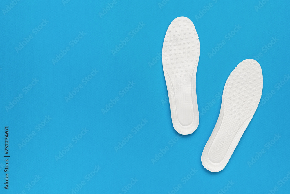 Bright white shoe insoles on a blue background. Bright white shoe insoles on a blue background.