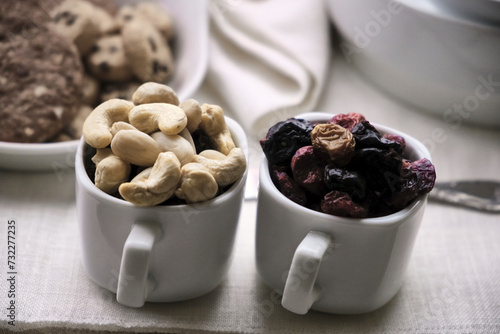 Dried fruit and red fruits in cups, whole grain cookies with chocolate complete the tray. Close-up. photo