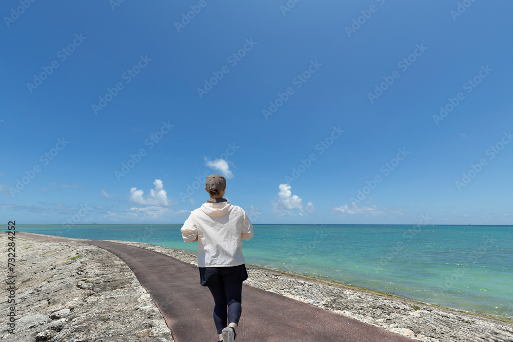 沖縄の海岸をジョギングする女性