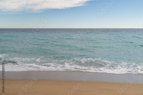 Empty sand beach on Mediterranean sea with horizon line vacation background