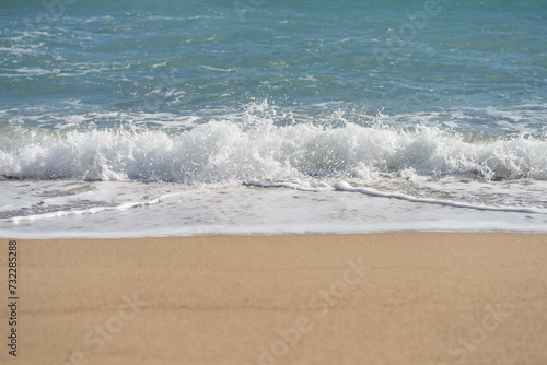 Waves rolling on a sandy beach on a sunny day