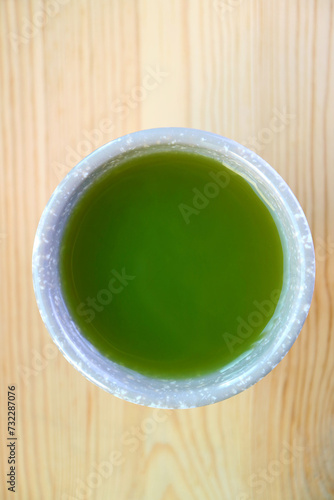 Cup of Hot Japanese Matcha Green Tea Isolated on Wooden Table