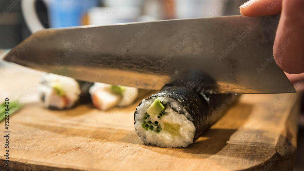 krojenie rolek sushi tradycyjnym nożem japońskim - obrazy, fototapety, plakaty 