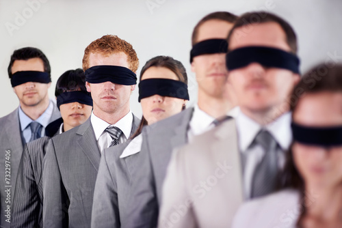Business people, blindfold and employees lost at work, together and coworkers trust in workplace. Blind, team and collaboration in uncertainty, control strategy and support in challenge or workforce photo