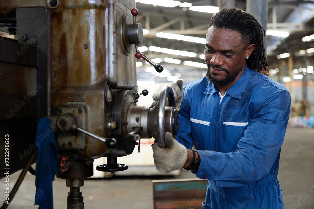African worker or technician checking and control lathe machine in factory African worker or technician checking and control lathe machine in factory